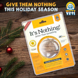 Alternative Product Image: "It's Nothing!" prank gift on a wooden surface with Christmas ornaments, suggesting it as a holiday gift.