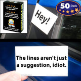 Alternative product image: Hand placing a 'The lines aren't just a suggestion, idiot.' bad parking card on a blue car window, with the card box visible.